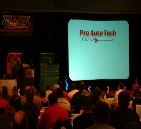 The Pro Auto Tech logo on a big screen at a training event